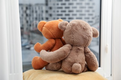 Photo of Teddy bears on window sill at home, back view