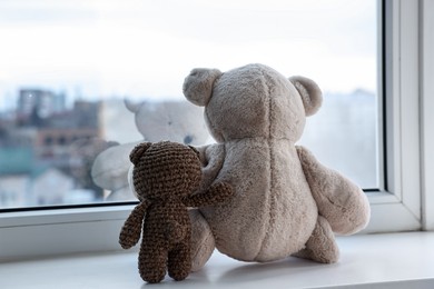 Photo of Two cute teddy bears near window indoors, back view