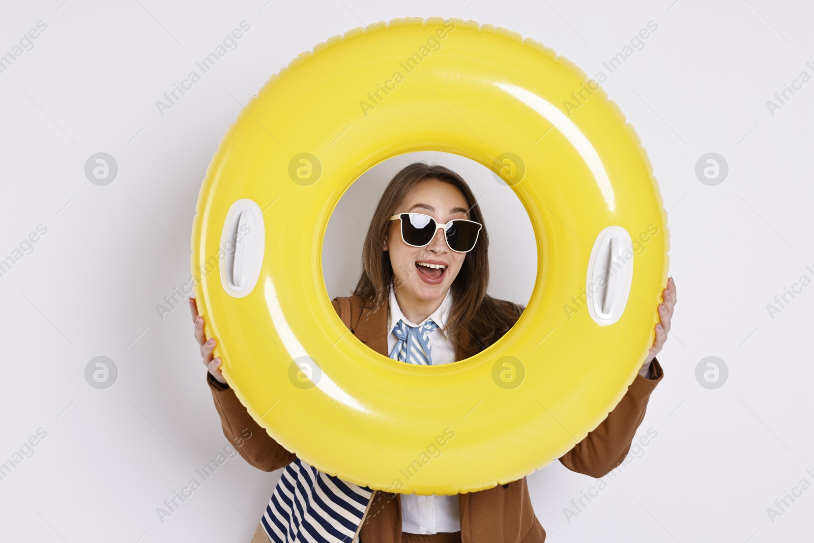 Photo of Businesswoman with inflatable ring, bag and sunglasses on white background