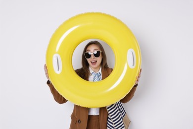 Photo of Businesswoman with inflatable ring, bag and sunglasses on white background