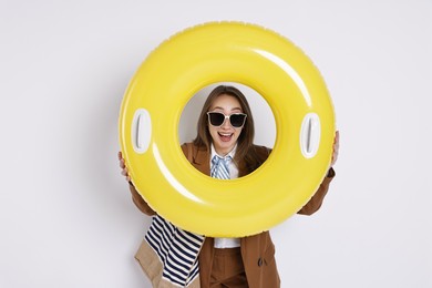 Photo of Businesswoman with inflatable ring, bag and sunglasses on white background