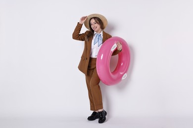 Photo of Businesswoman with inflatable ring and straw hat on white background