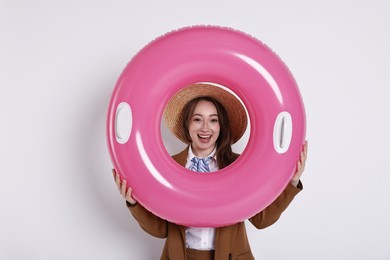 Photo of Businesswoman with inflatable ring and straw hat on white background