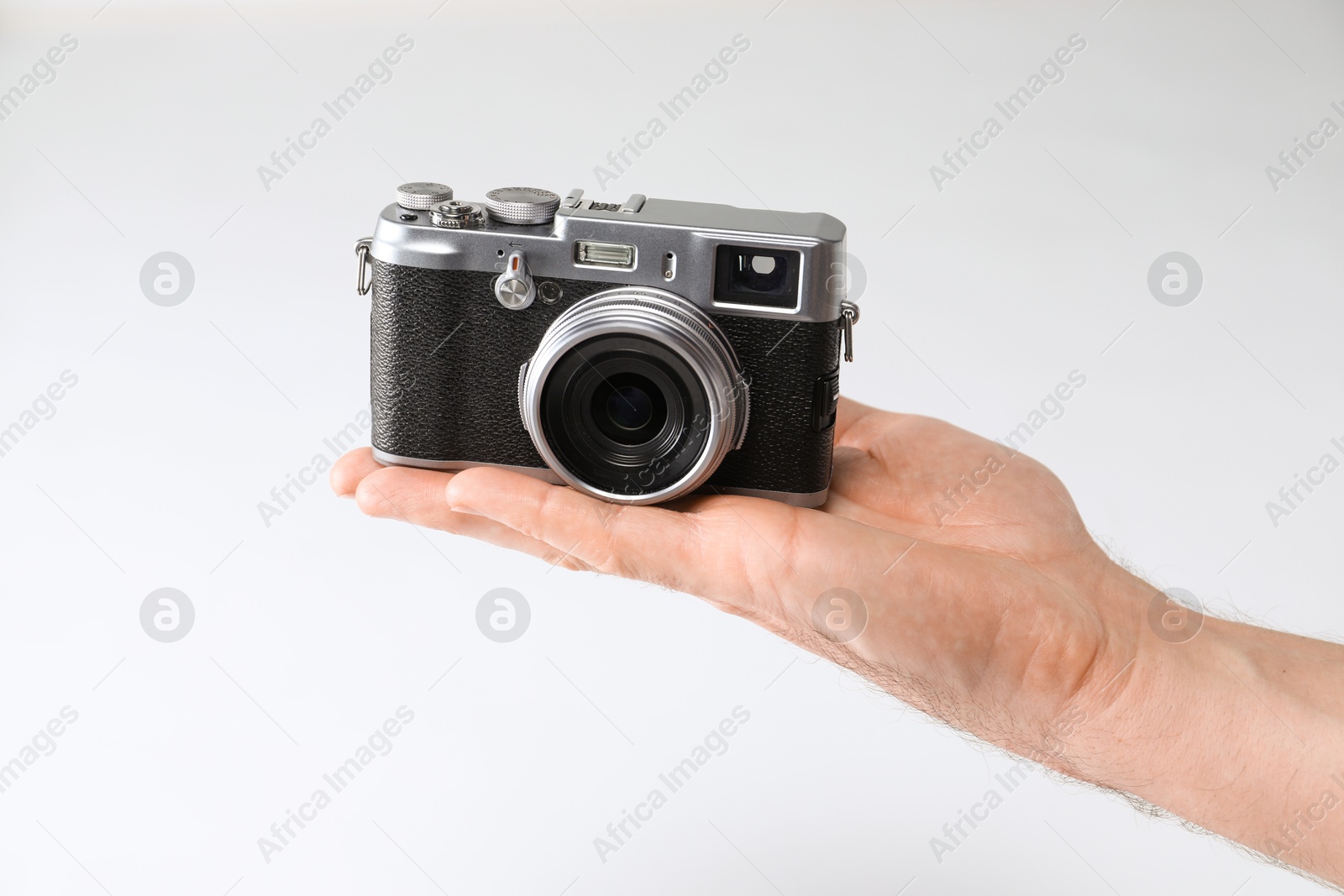 Photo of Photographer with vintage camera on white background, closeup