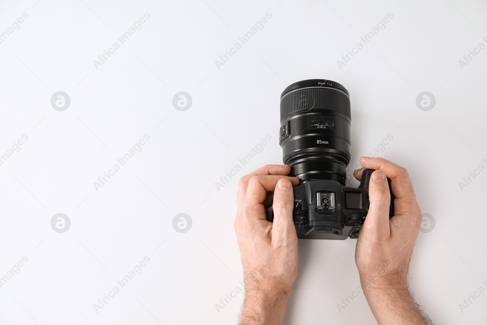 Photo of Photographer with professional camera on white background, top view. Space for text