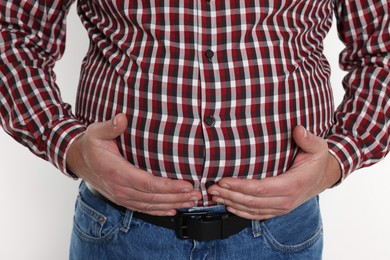 Photo of Overweight man in tight shirt on white background, closeup