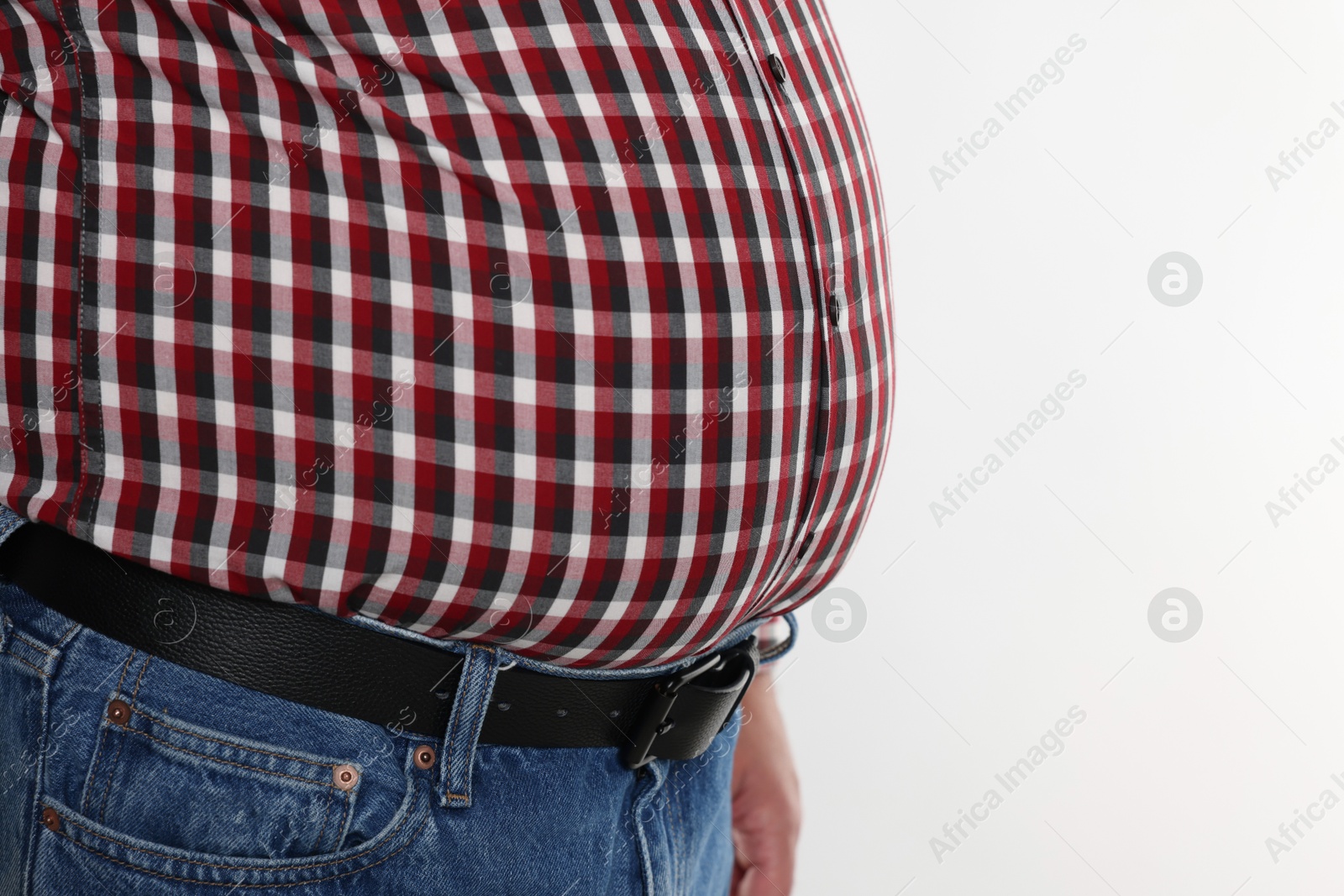 Photo of Overweight man in tight shirt on white background, closeup. Space for text