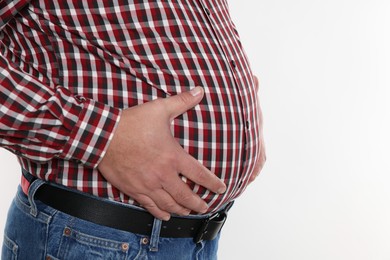 Photo of Overweight man in tight shirt on white background, closeup. Space for text