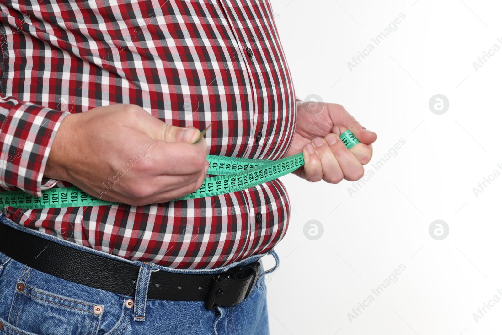 Photo of Overweight man measuring his belly with tape on white background, closeup. Space for text