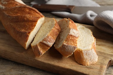 Photo of Pieces of fresh baguette on wooden table, closeup