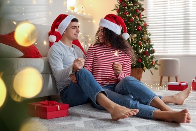 Photo of Happy couple with sparklers at home. Christmas celebration