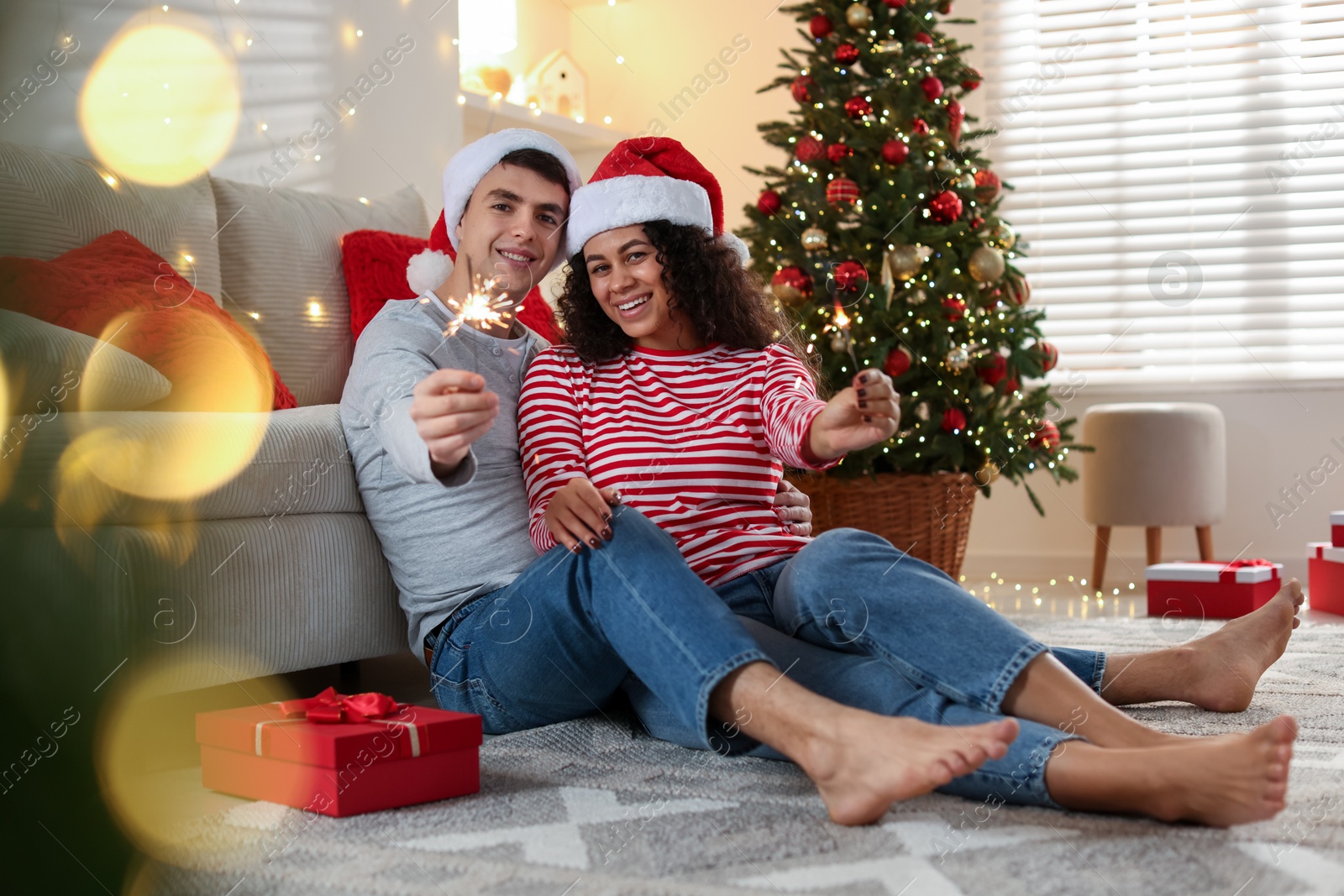 Photo of Happy couple with sparklers at home. Christmas celebration