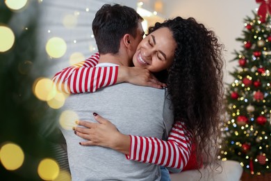 Photo of Happy couple hugging at home. Christmas celebration