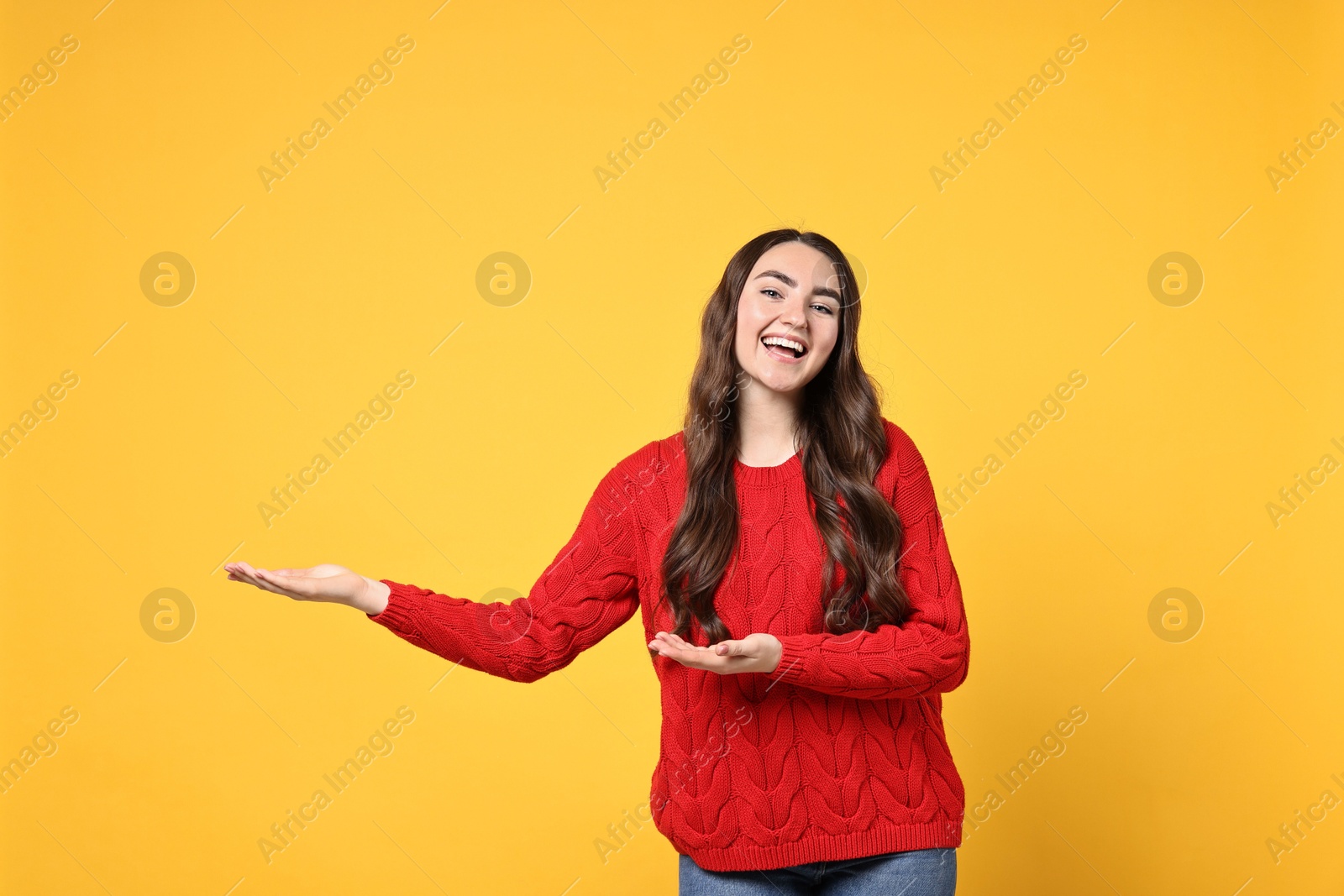 Photo of Happy woman welcoming friends or guests on yellow background