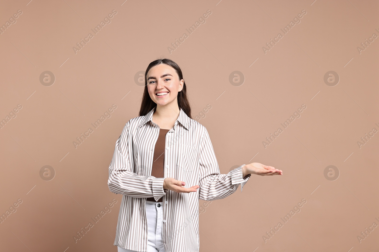 Photo of Happy woman welcoming friends or guests on beige background