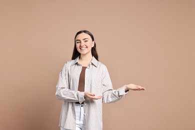 Photo of Happy woman welcoming friends or guests on beige background