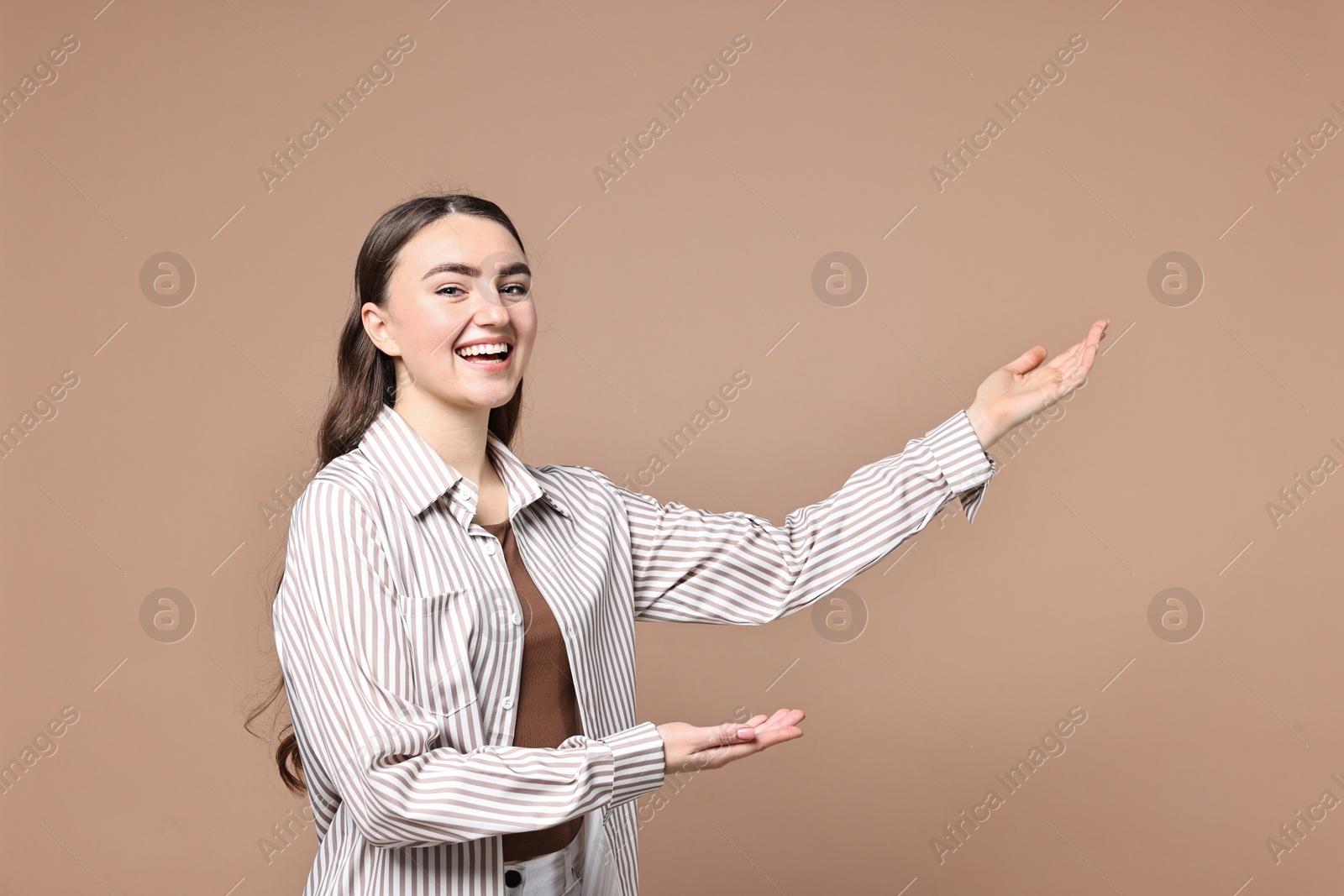 Photo of Happy woman welcoming friends or guests on beige background