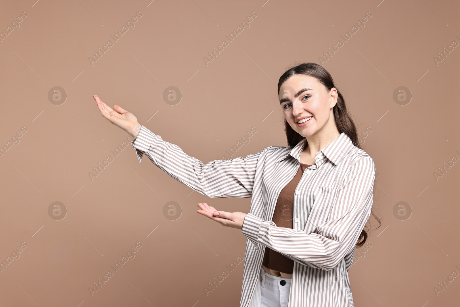 Photo of Happy woman welcoming friends or guests on beige background. Space for text