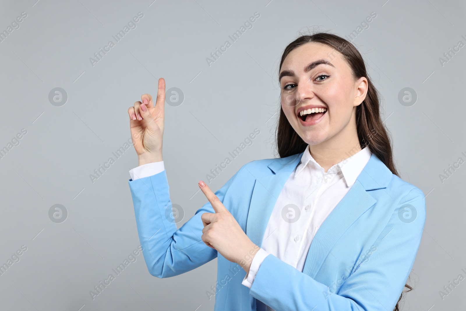 Photo of Happy businesswoman welcoming clients or partners on grey background