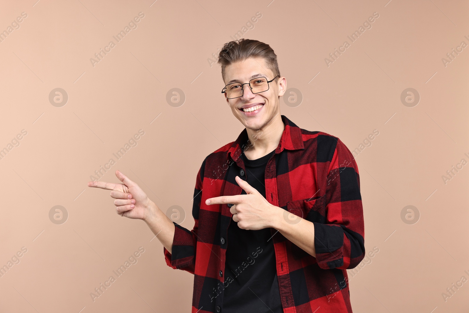 Photo of Happy man welcoming friends or guests on beige background