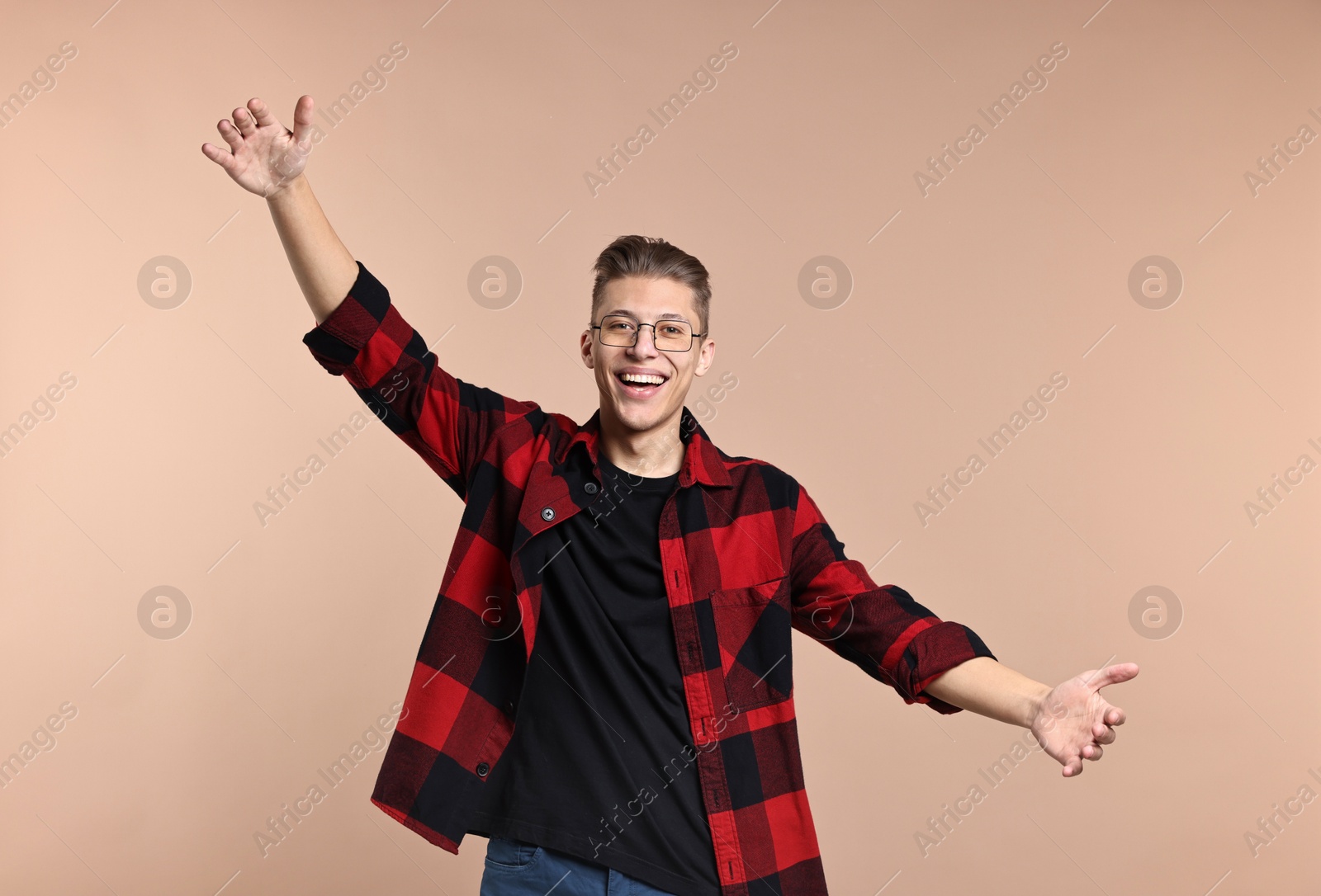 Photo of Happy man welcoming friends or guests with wide open arms on beige background