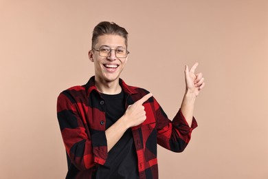 Photo of Happy man welcoming friends or guests on beige background