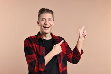 Photo of Happy man welcoming friends or guests on beige background