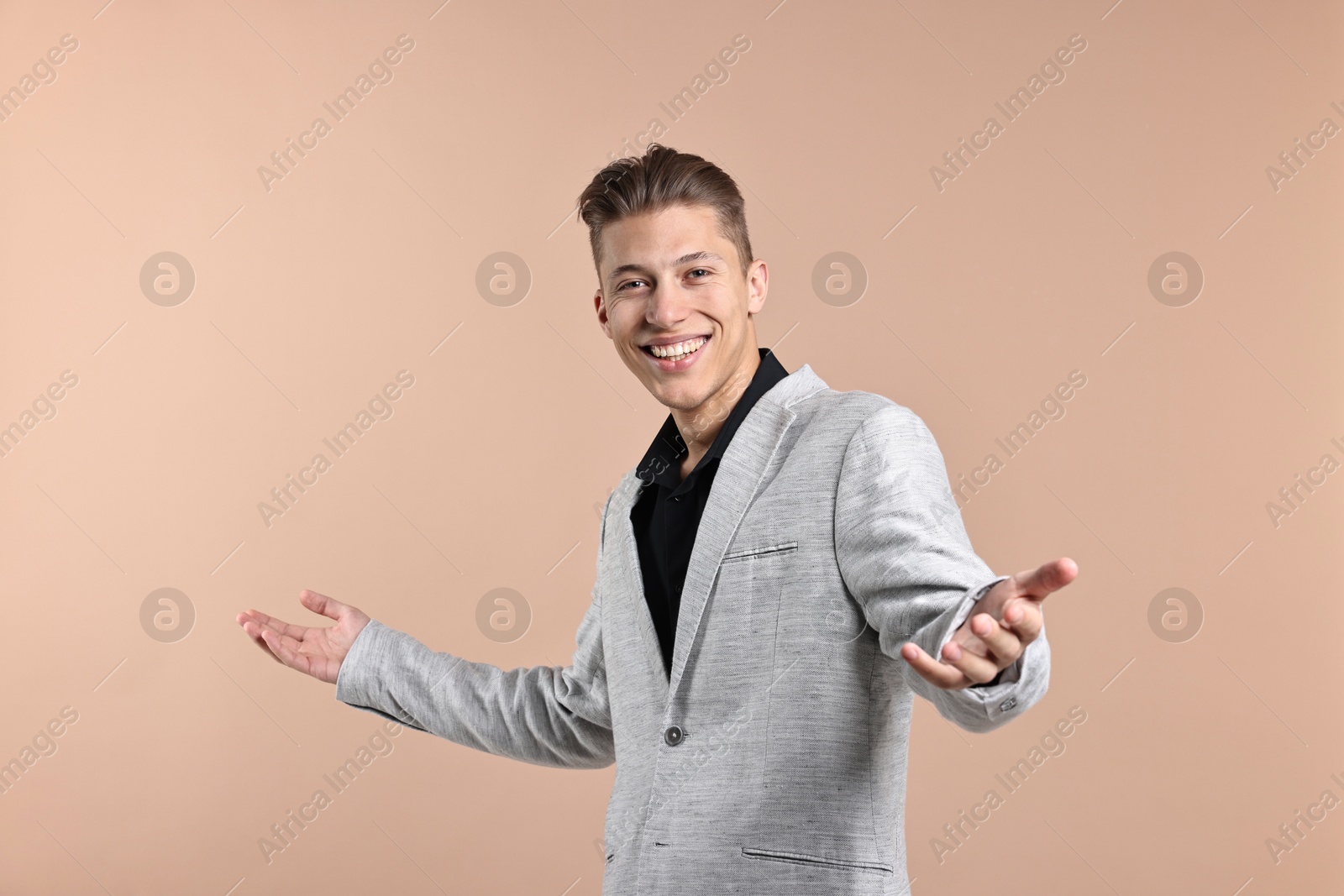 Photo of Happy businessman welcoming clients or partners on beige background