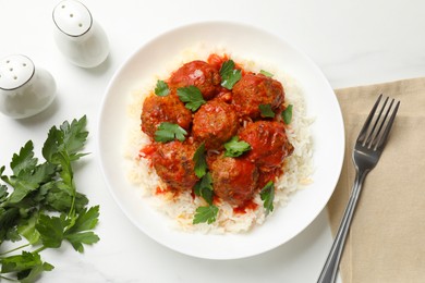 Photo of Delicious meatballs with rice, sauce and parsley served on white table, flat lay