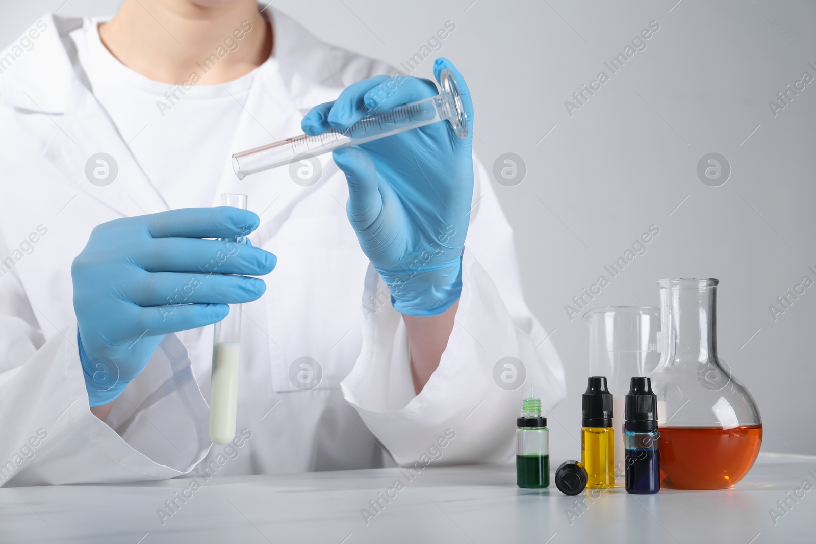 Photo of Laboratory testing. Scientist working with glassware at white marble table, closeup