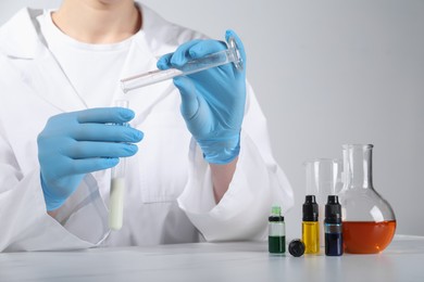 Photo of Laboratory testing. Scientist working with glassware at white marble table, closeup