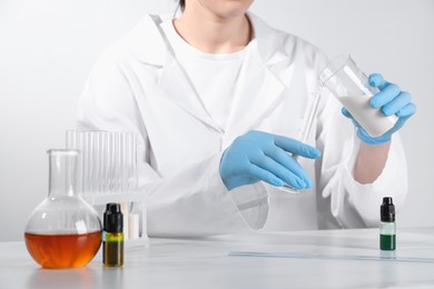 Photo of Laboratory testing. Scientist working with glassware at white marble table, closeup