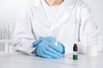 Photo of Laboratory testing. Scientist working with glassware at white marble table, closeup