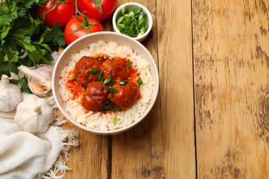 Photo of Tasty meatballs with sauce, rice and products on wooden table, flat lay. Space for text