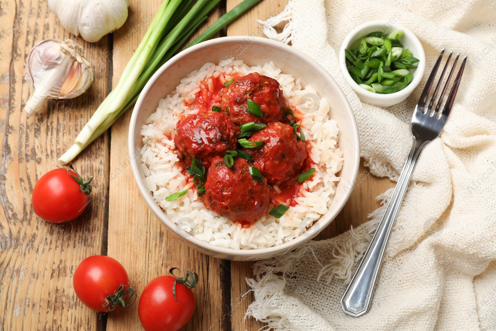 Photo of Tasty meatballs with sauce, rice and products on wooden table, flat lay