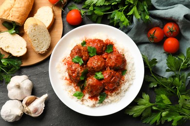 Photo of Tasty meatballs with sauce, rice and products on black table, flat lay