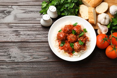 Photo of Tasty meatballs with sauce, rice and products on wooden table, flat lay. Space for text