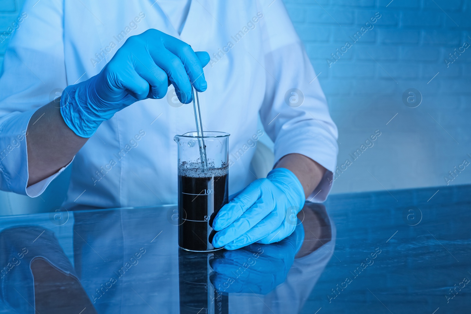 Photo of Laboratory testing. Scientist preparing soil extract at table indoors, closeup. Space for text