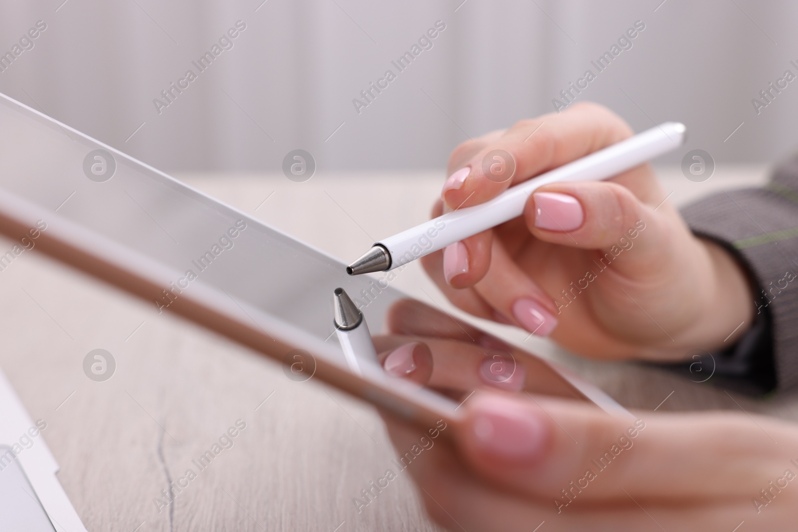 Photo of Electronic signature. Woman using stylus and tablet at wooden table indoors, closeup