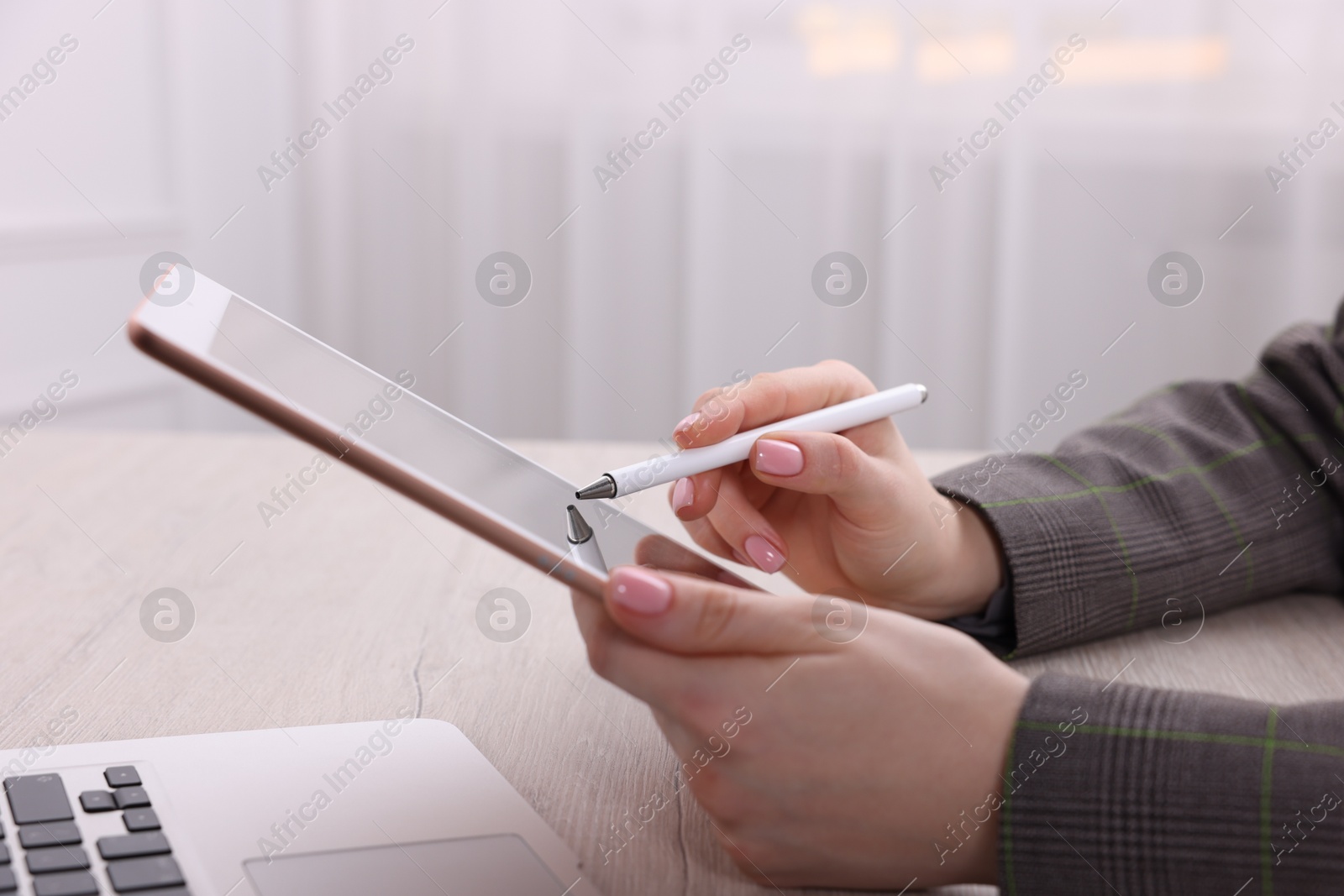 Photo of Electronic signature. Woman using stylus and tablet at wooden table indoors, closeup