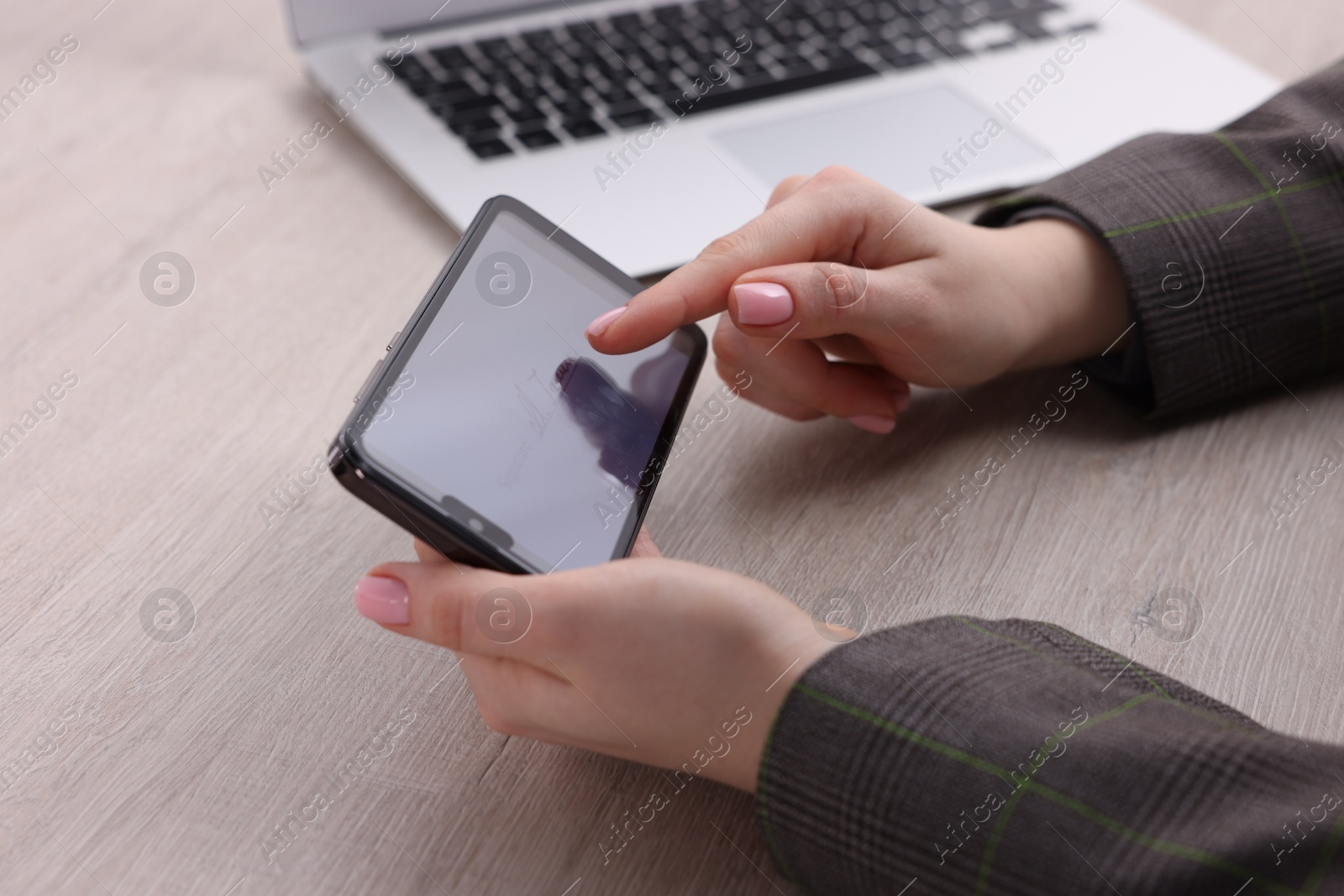 Photo of Electronic signature. Woman using smartphone at table, closeup