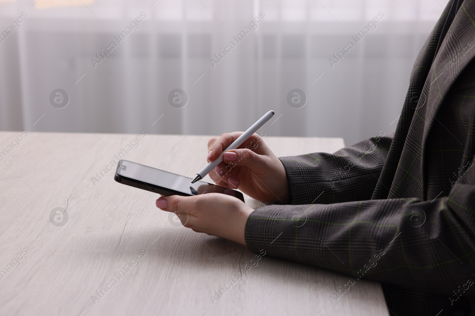 Photo of Electronic signature. Woman using stylus and smartphone at wooden table indoors, closeup