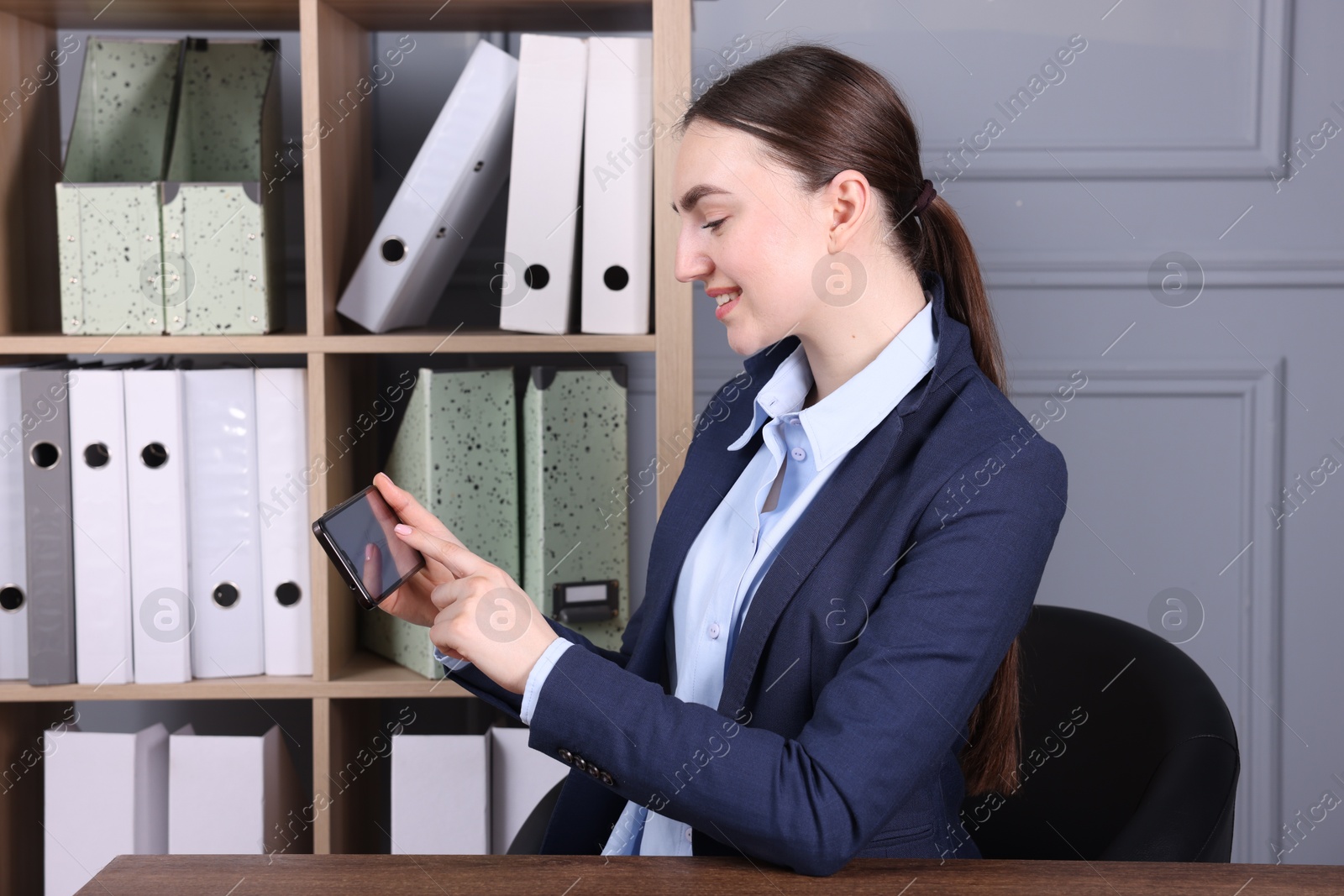 Photo of Electronic signature. Woman using smartphone in office