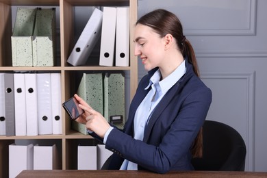 Photo of Electronic signature. Woman using smartphone in office