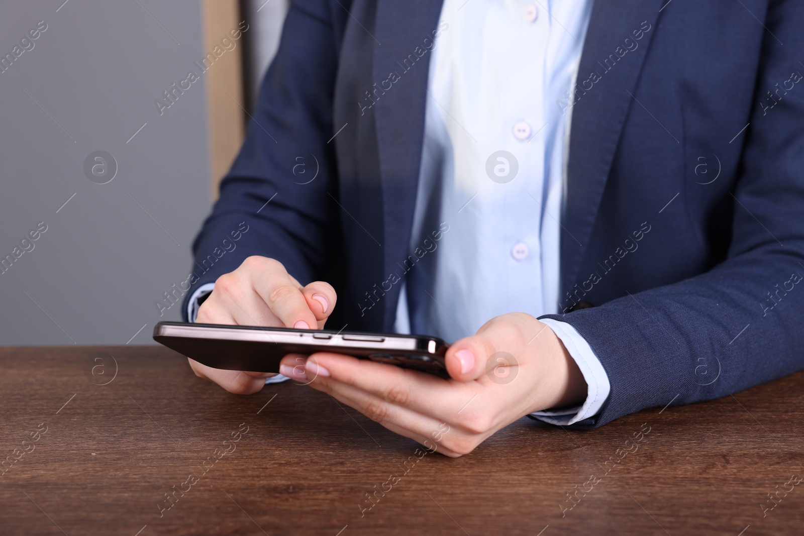 Photo of Electronic signature. Woman using smartphone at table, closeup