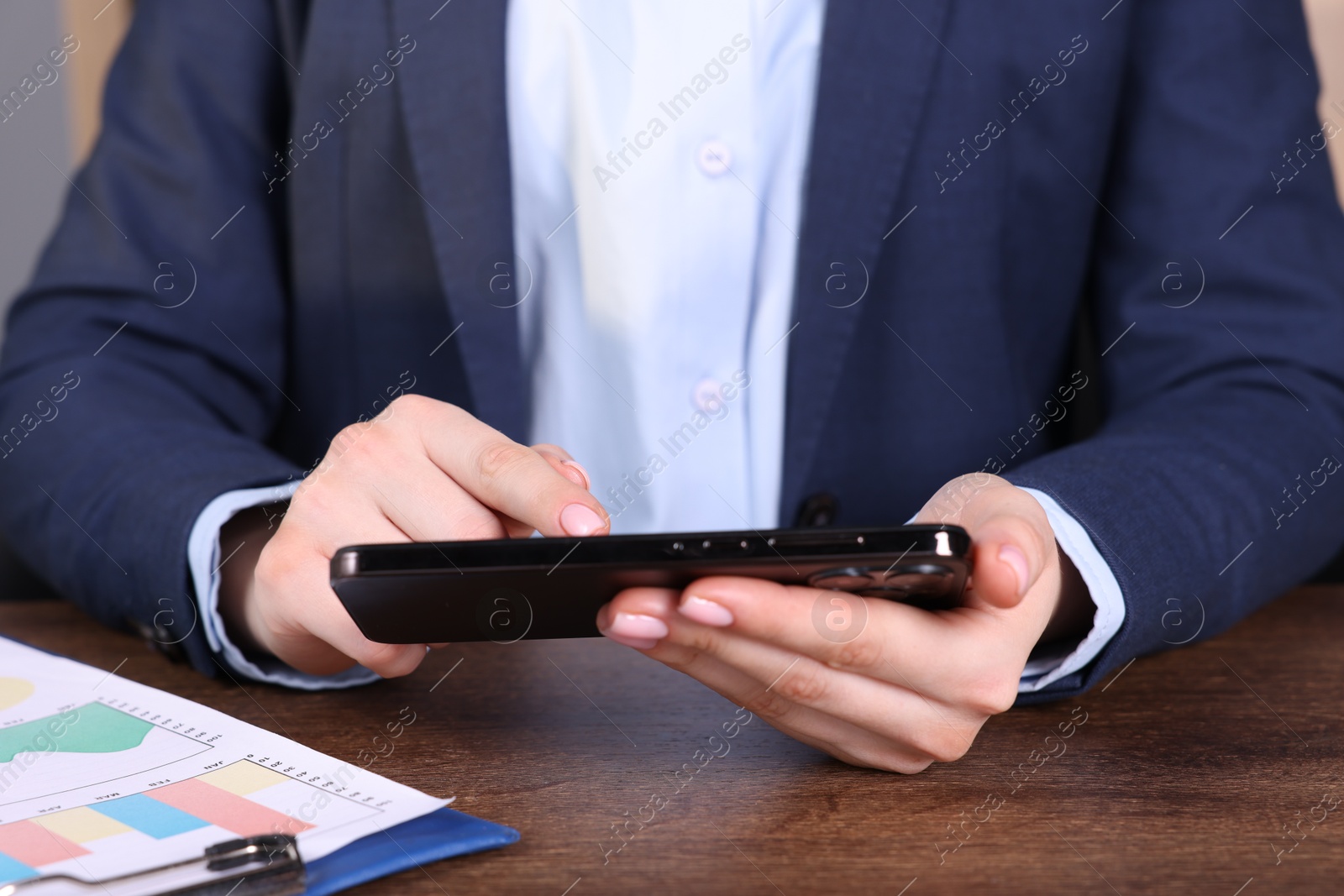 Photo of Electronic signature. Woman using smartphone at table, closeup