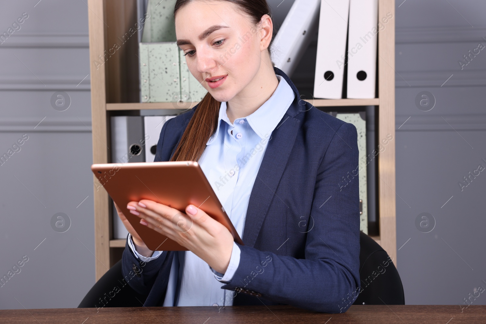 Photo of Electronic signature. Woman using tablet at wooden table indoors