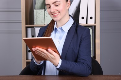 Photo of Electronic signature. Woman using tablet at wooden table indoors