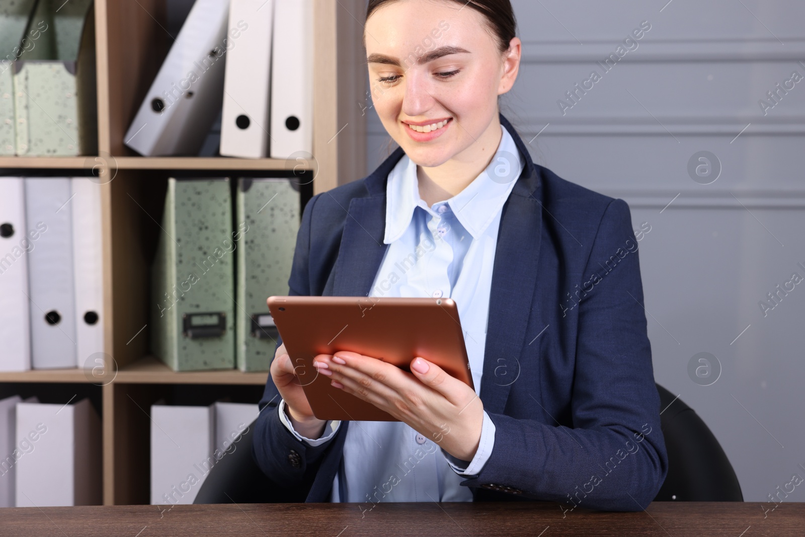 Photo of Electronic signature. Woman using tablet at wooden table indoors