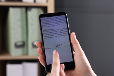 Photo of Electronic signature. Woman using smartphone indoors, closeup